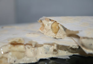 Nougat artisanal aux noisettes Vicens IGP Torro d'Agramunt déballé, tranche avec noisettes entières. Nougat très riche en noisettes (60%), texture croquante et fondante à la fois. IGP Turron de Agramunt. Suce miel.